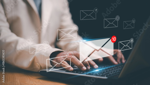 Business email communication concept. Businessman typing on laptop and virtual mail notification icons. Digital messaging, online inbox, customer support, marketing and modern office technology.