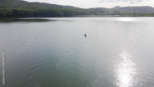 View from above. A rower trains on a kayak on the lake.