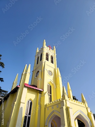 Front perspective of Christ Church Shimla illuminated by sunlight, with sharp architectural lines and a deep blue sky, emphasizing the landmark’s prominence in the town center.