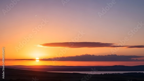 A breathtaking and tranquil evening scene unfolds with a vibrant orange and purple sunset over a calm lake, silhouetting distant hills under a sky graced by a delicate crescent moon