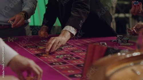 Hands Placing Bets on Roulette Table Before Wheel Spin