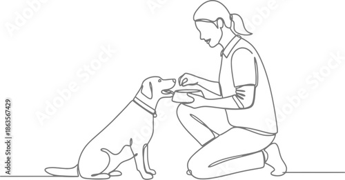 Woman kneeling beside dog receiving treat