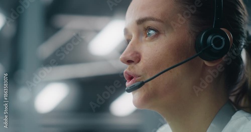 Close Up of Dedicated Female Technician Responding to Real Time System Alerts, Communicating Via Headset at Console in Data Center. Concept of Critical Incident Management and Rapid Response.