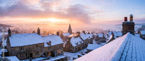 Winter Sunrise Over Snow Covered Village Rooftops With Golden Morning Light