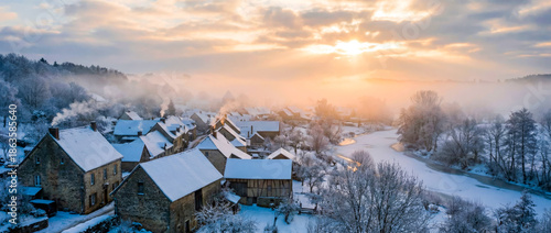 Magical Winter Sunrise Over Snow-Covered Village with River and Smoke