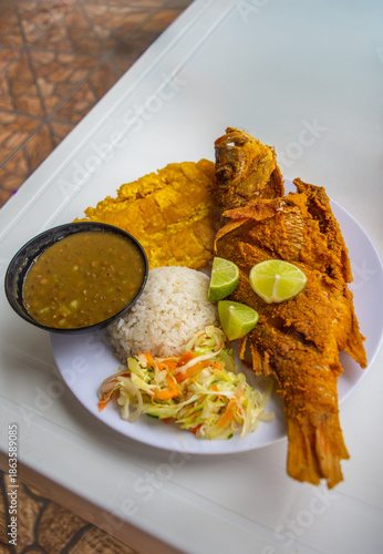 Delicious plates of fried fish, rice, plantains, and salad served in San Cipriano, Buenaventura, Valle del Cauca, Colombia.