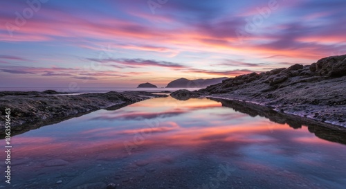 Pink And Purple Sunset Reflecting On Calm Ocean Water