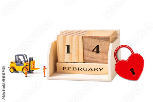 Miniature people with wooden calendar 14 February and red heart shape  on white background.