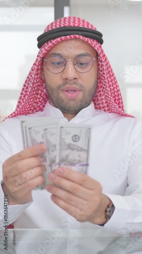 Young Muslim Man Counting Money at Work, vertical video
