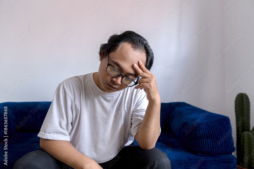 Obraz premium A man holds his head in disappointment over his baldness problem, hair loss treatment, Concept of baldness treatment or hair restoration