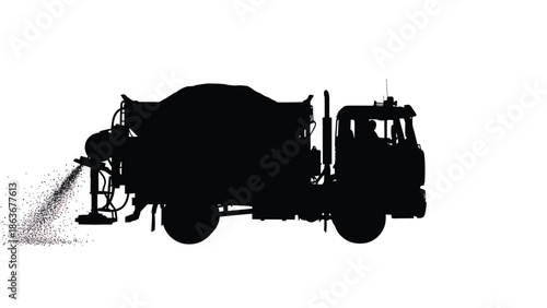 A striking silhouette of a concrete mixer truck actively spraying material highlighting industrial work high quality