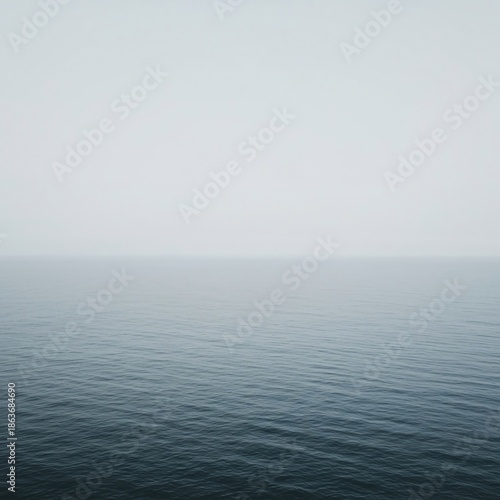 Vast, empty ocean scene with a soft, misty horizon line blending the sea and sky seamlessly. Perfect background, water, negative space, tranquil