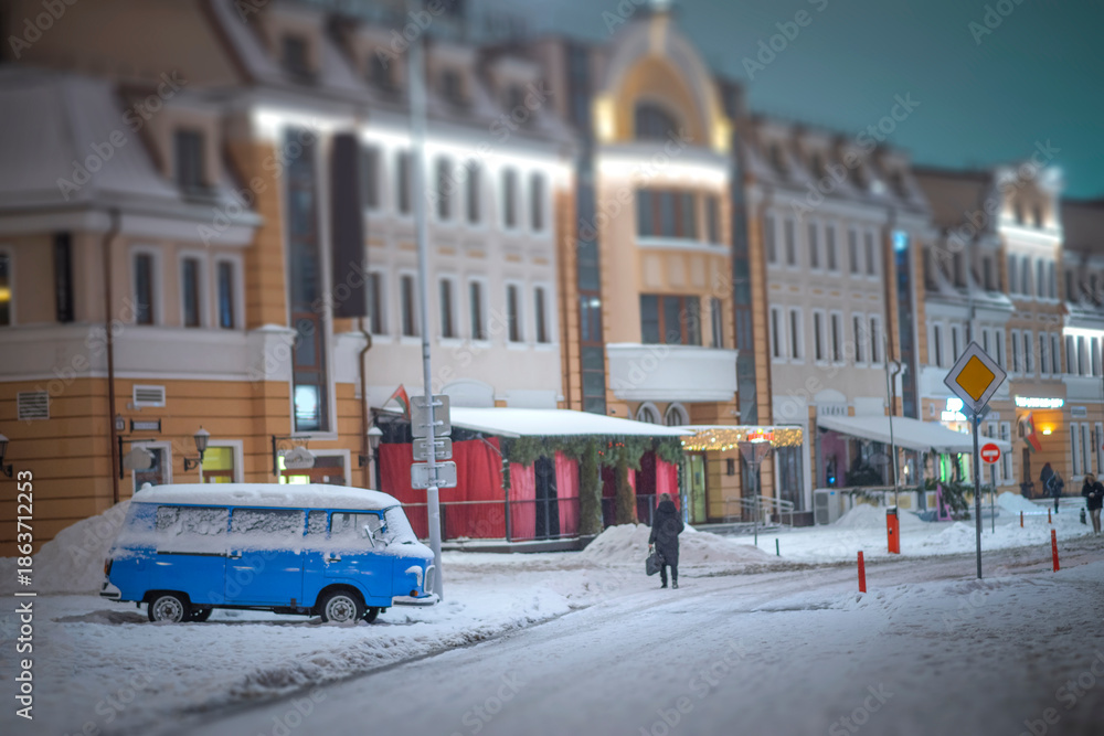 Obraz premium A winter night in Minsk. A car on the street is covered in snow.