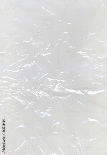 Abstract crumpled plastic texture with glowing light reflections creating a metallic and futuristic effect. Shiny surface and intricate folds form abstract background for modern design concepts.