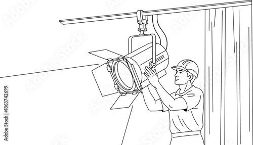 Worker adjusting studio lighting equipment