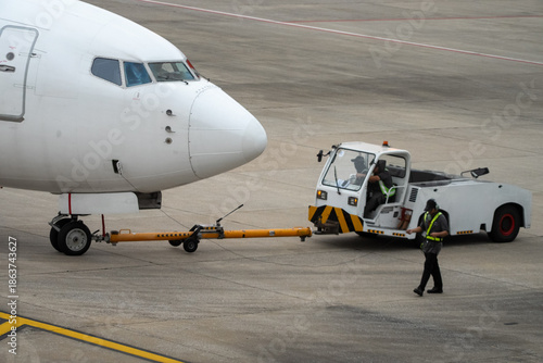 Fotografia A white airplane is being towed by a white truck