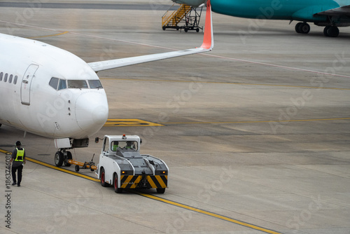 A white airplane is being loaded with luggage