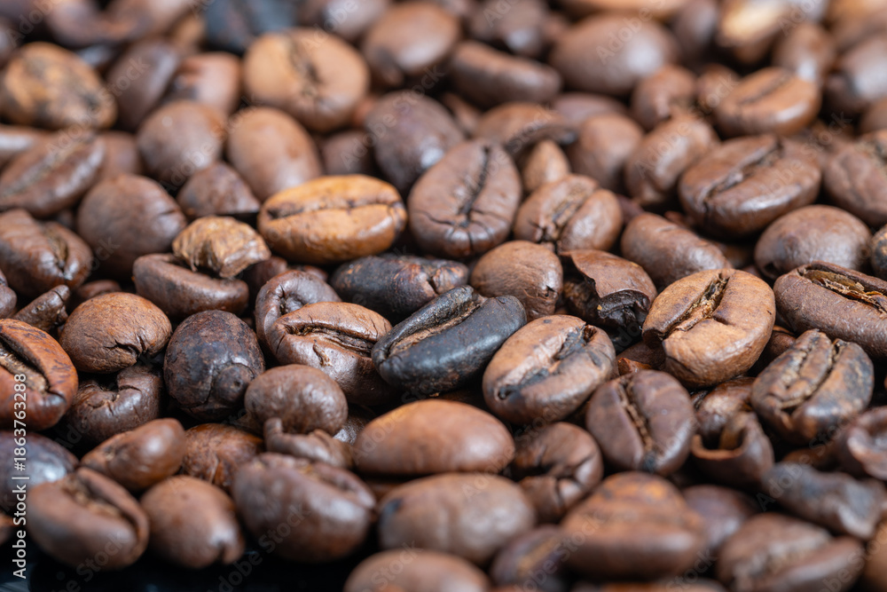 Fototapeta premium Coffee beans overview, Closeup of medium roasted coffee beans highlighting features, Highresolution image showcasing medium roasted coffee beans with surface oils and textures