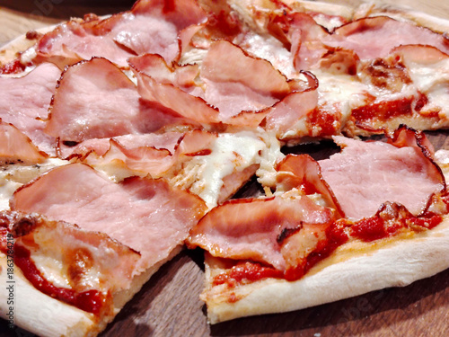 Sliced ham pizza with melted cheese and tomato sauce.