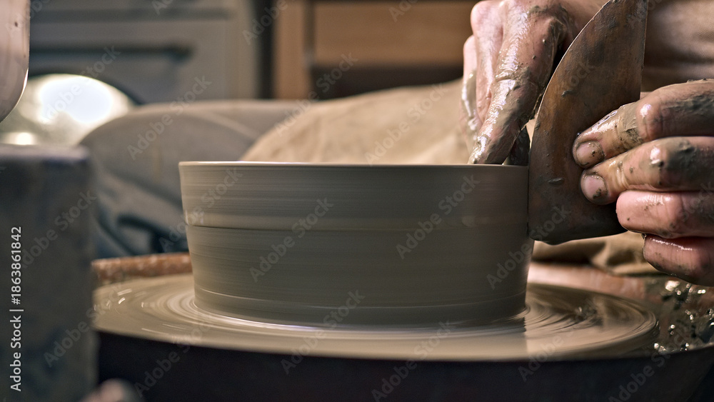 Αυτοκόλλητο A craftsperson shapes a clay pot on a pottery wheel, their hands skillfully guiding the spinning clay