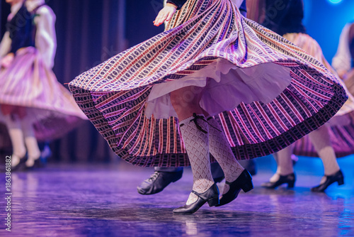 Latvian folk dancers in vibrant traditional costumes twirl gracefully on stage, showcasing cultural heritage and lively performance art