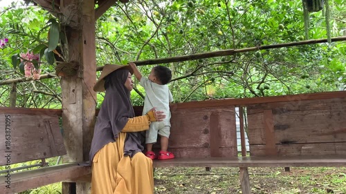 Joyful mother and child exploring a vibrant Citrus limon fruit tree garden