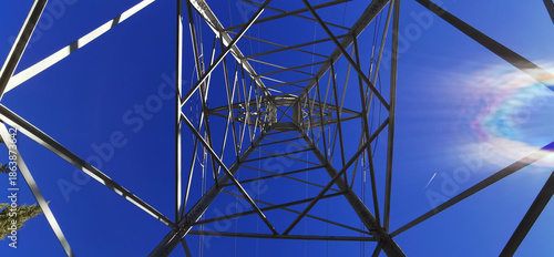 Symmetrical image of a high voltage electrical tower with the sky in the background