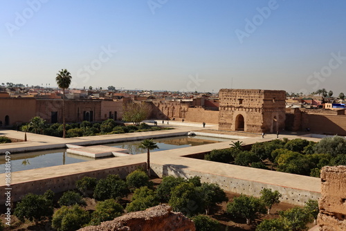 View of El Badi Palace ruins in Marrakech, Morocco, with historic walls, reflecting pools and gardens under clear blue sky, representing history and cultural heritage