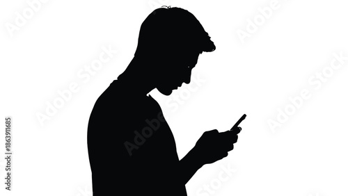 Silhouette of a young man intensely focused while looking down and using his modern mobile smartphone