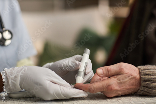 Wallpaper Mural Caucasian senior receiving blood sugar test from medical professional wearing gloves, healthcare worker holding glucometer and pricking finger for diabetes monitoring Torontodigital.ca