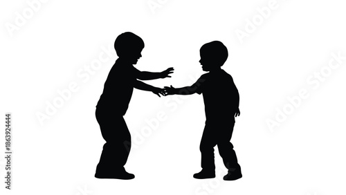 Silhouette of two young playful boys reaching out to touch hands in greeting or play
