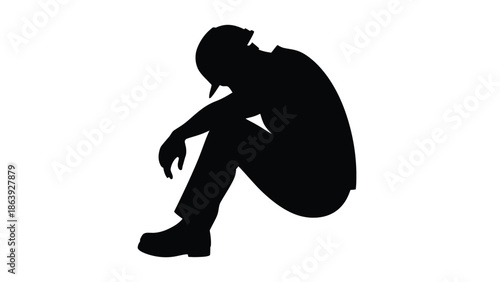 Silhouette of a defeated worker or laborer sitting alone in despair and deep exhaustion