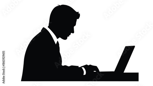 Silhouette of a focused businessman working intently on a modern laptop computer in an office setting