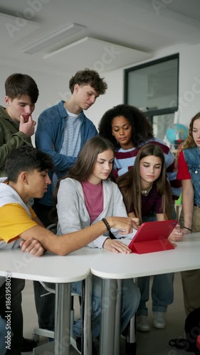 Teen students learning together with digital tablet in modern classroom.