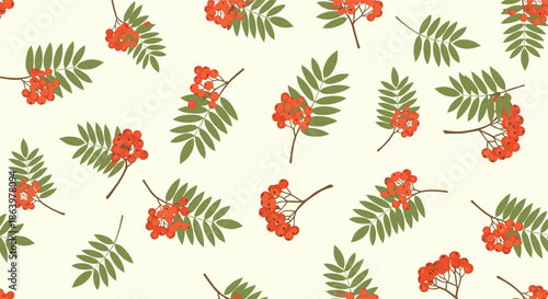 Autumnal seamless pattern showing clusters of red rowan berries and green leaves scattered on a cream background.