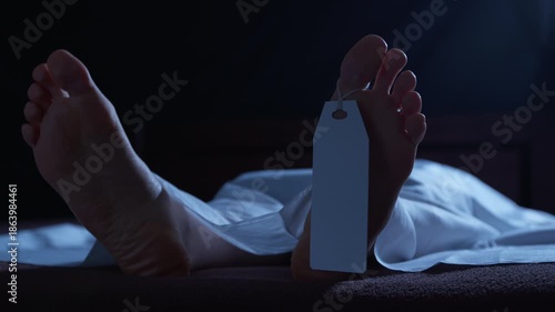 A human corpse lying in a morgue, covered with a white sheet and a tag on its leg. Concept of a dead person, a deceased person.