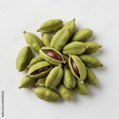 Aromatic green cardamom pods scattered showing fragrant seeds inside culinary spice
