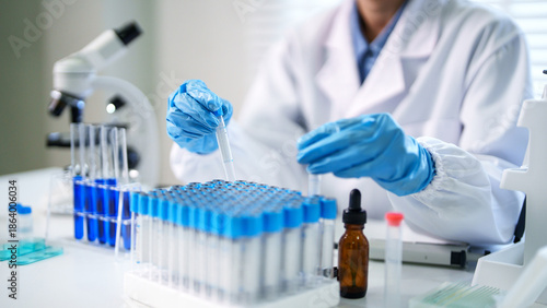 Foto Adult scientist hands pipetting blue liquid test tubes conducting lab experiment
