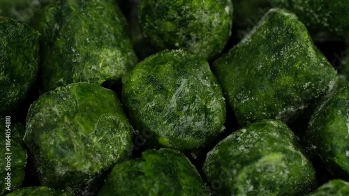 Heap of frozen Spinach cubes close up, rotation