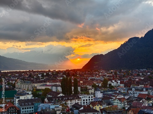 Fotografie Elevated view of Interlaken at sunset with golden light over the town architectu