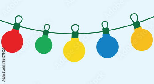 Colorful string of round festive lights in red green yellow and blue hanging from a wire against a light blue background for holiday themes.
