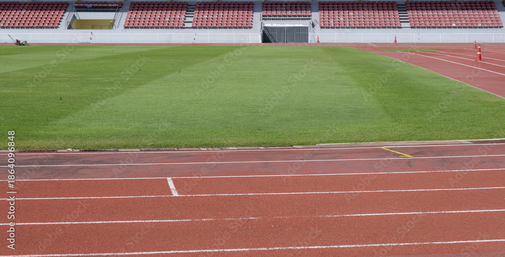 Fototapeta premium Outdoor sports stadium with a red running track with white lane markings