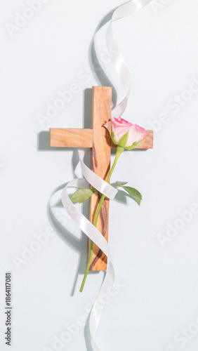 Spiritual Vertical Composition with Wooden Cross, Pink Rose, and Elegant White Ribbon. Minimalist Aesthetic Concept of Faith, Grace, and Love for Christian Branding, Easter, or Sympathy Designs