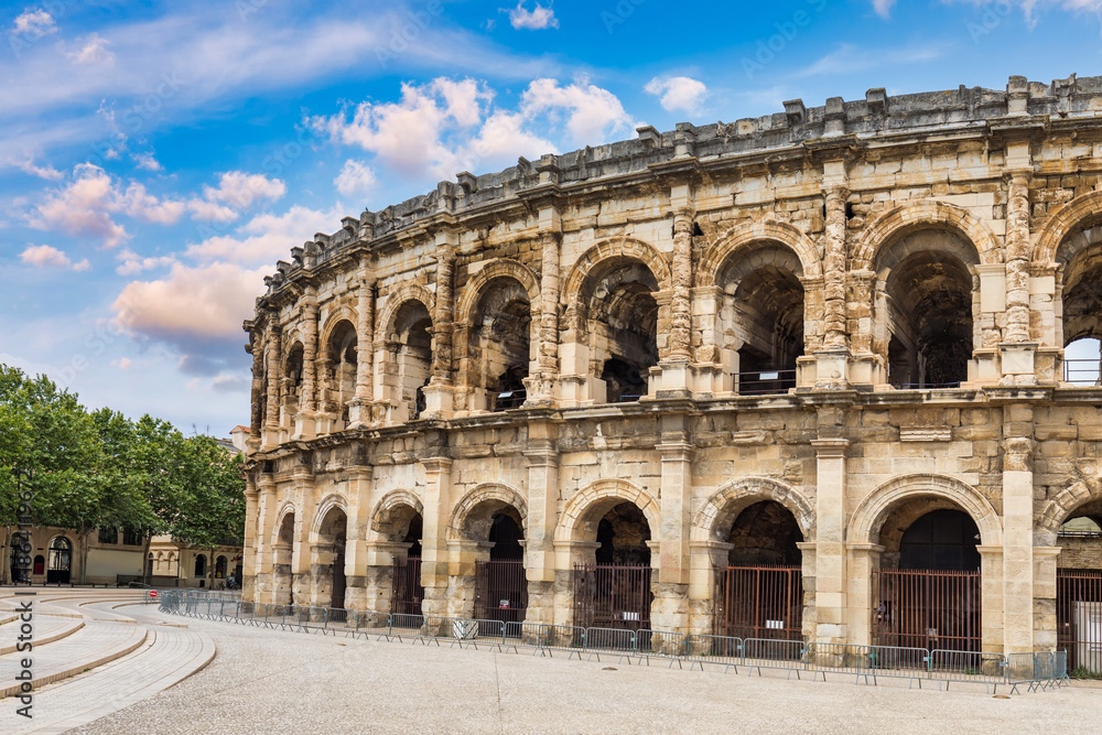 Fototapeta premium This historic Roman amphitheater in Nimes showcases ancient architecture. Historic Roman amphitheater in Nimes, Gard, France with beautiful sky. Nimes, Gard, France.
