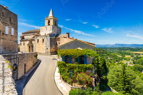 View of Venasque village with old church Notre Dame de Vie to landscape of Luberons, Provence, France. Beautiful Church and houses in the town of Venasque, Provence, France.