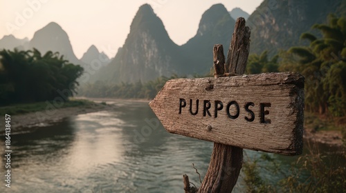 A weathered sign pointing towards purpose along a tranquil river landscape