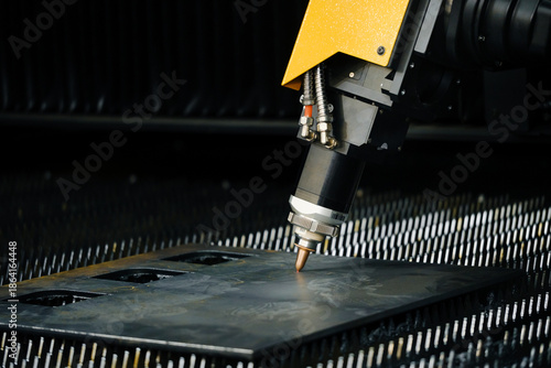 Foto fiber laser cutting machine head with nozzle precisely cutting contours in sheet