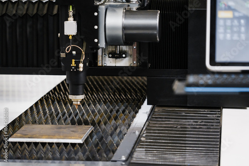 Foto CNC fiber laser cutting head positioned above sheet metal on lamella support tab