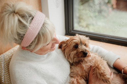 Tableau sur toile Elderly woman with blonde hair and pink headband relaxing in a chair with her sm