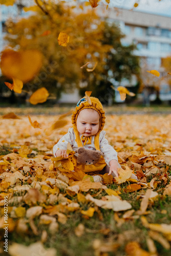 Baby Girl Rejoices, Smiles Sincerely Because Of Falling Autumn Leaves In Warm